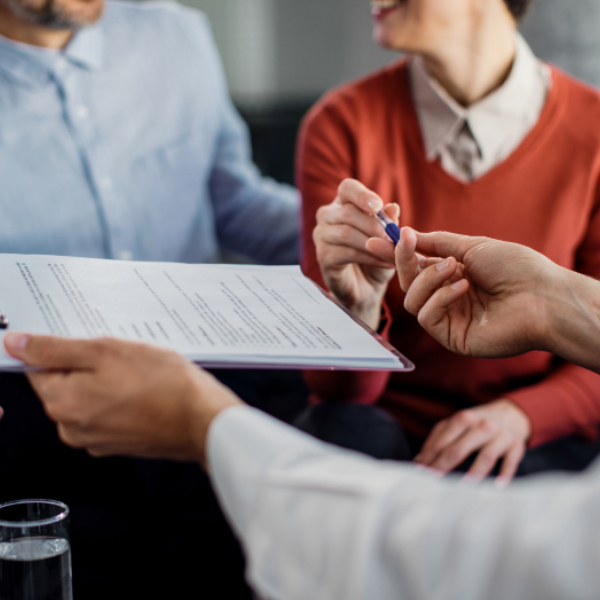 closeup-unrecognizable-couple-signing-contract-with-financial-advisor